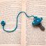 Blue Spotted Mushroom Bookmark With Round Crocheted Ponpon on book