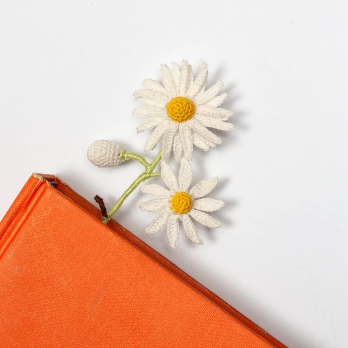 Two White Micro Crochet Handmade Daisy Flower Bookmark On Book Angle Shot